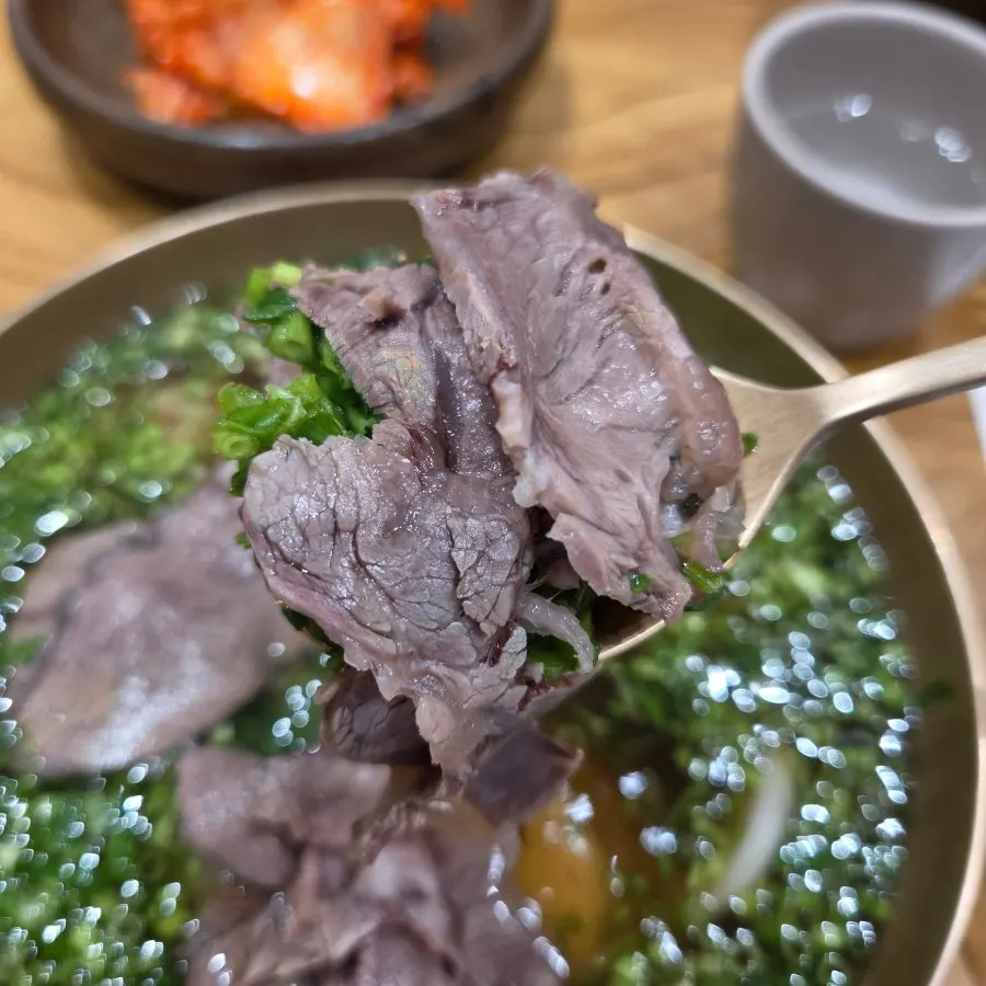 Korean beef lifted out of the gomtang on a spoon