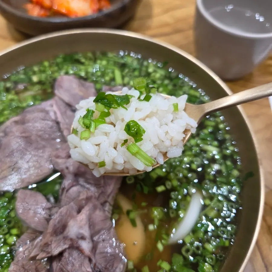 Clear-broth minari gomtang with rice cake and rice inside