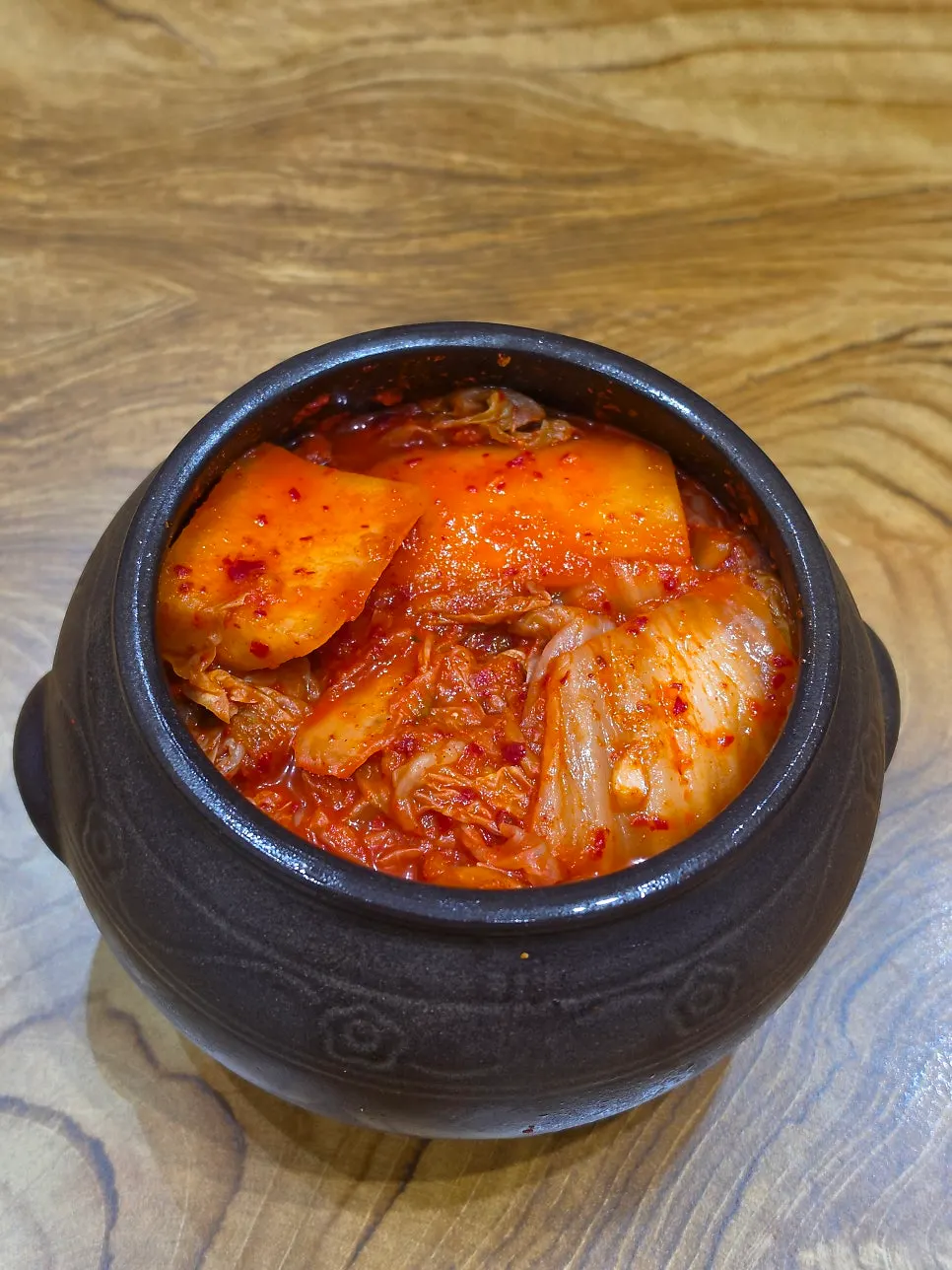 Adding kimchi on top of the gomtang