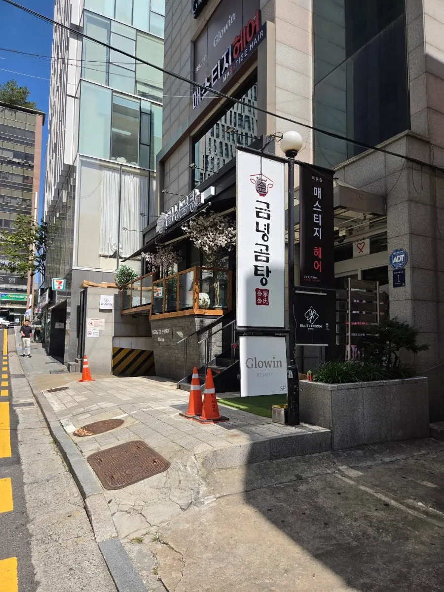 블랙 외관과 우드톤 테라스가 있는 금녕곰탕 역삼점 입구