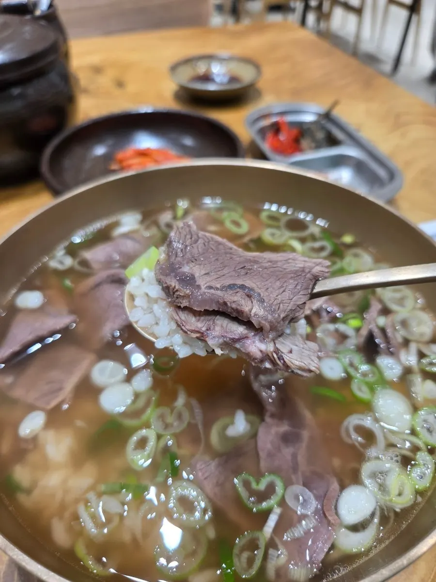 곰탕 고기 한 점을 밥과 함께 먹는 모습