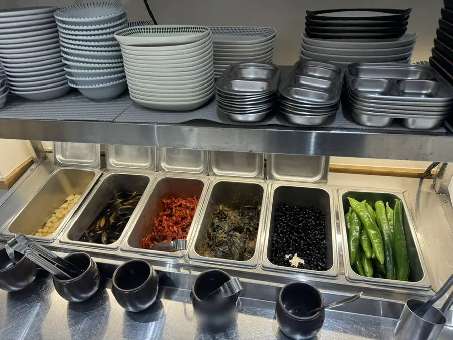 A neat spread of banchan including cucumber peppers and pickles