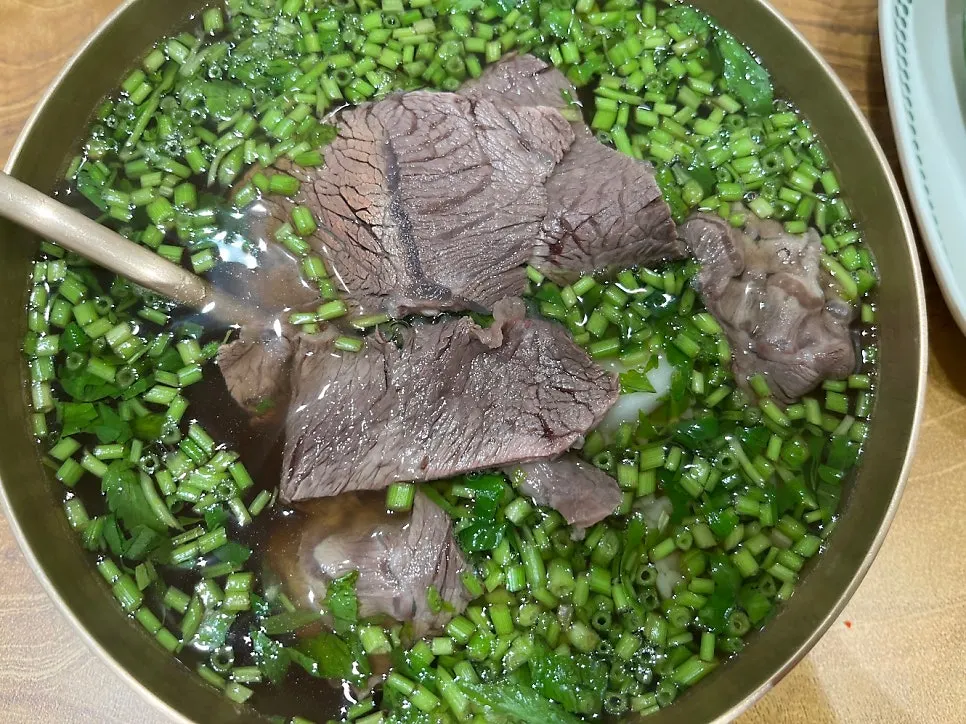 A bowl of minari gomtang topped with water dropwort