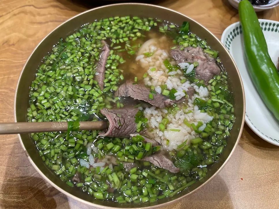 Close-up of minari gomtang broth and meat