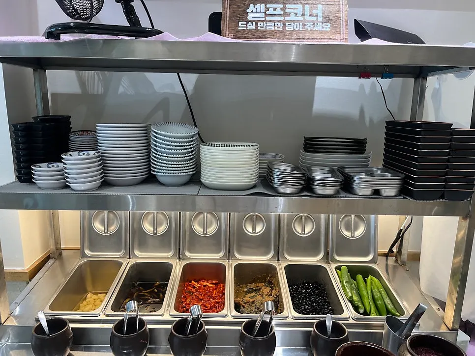 Self-serve corner with chili peppers, seasoned soybeans, and other banchan