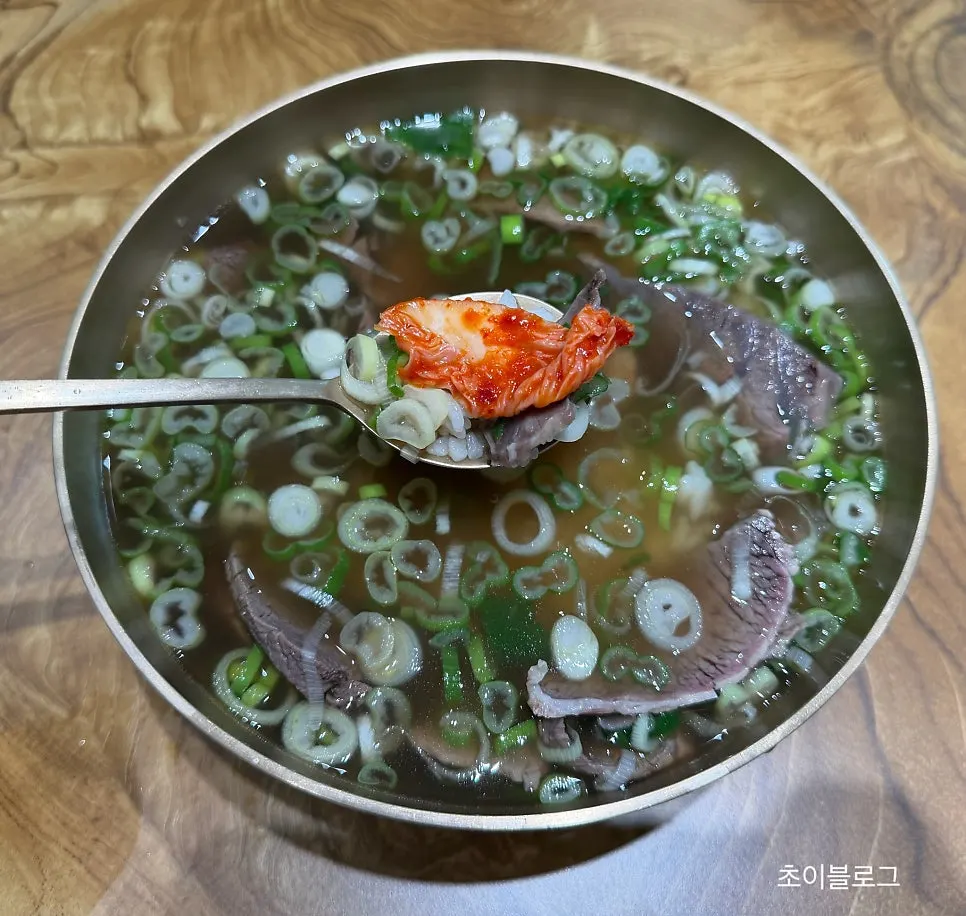 A spoonful of gomtang with meat piled on rice
