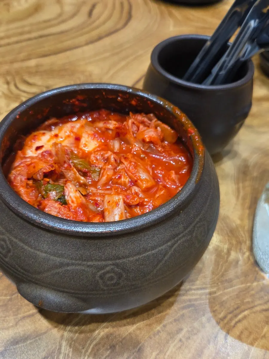 Simple table setting of brass-bowl gomtang and kimchi