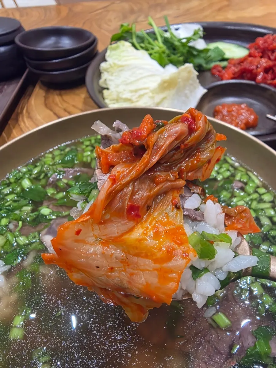 곰탕에 밥과 김치를 얹은 한 숟갈