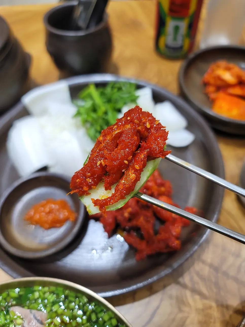 배추에 미나리와 명태회를 올린 한 입