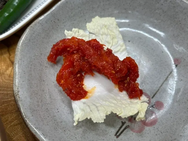 A bite of pollock salad on a piece of cabbage