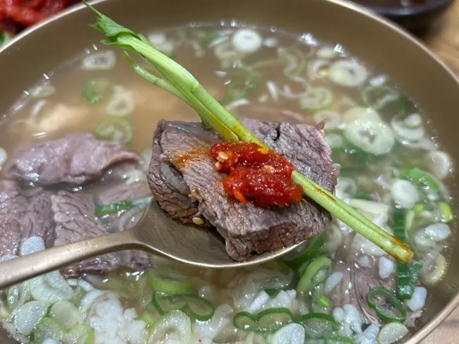 The three-way combo of gomtang meat, pollock salad, and minari