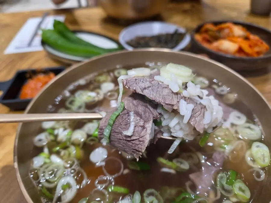 밑반찬을 곁들인 곰탕 식사 상차림