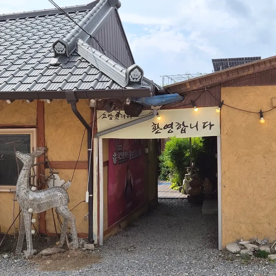 마당있는집 간판과 식당 앞 주차 공간