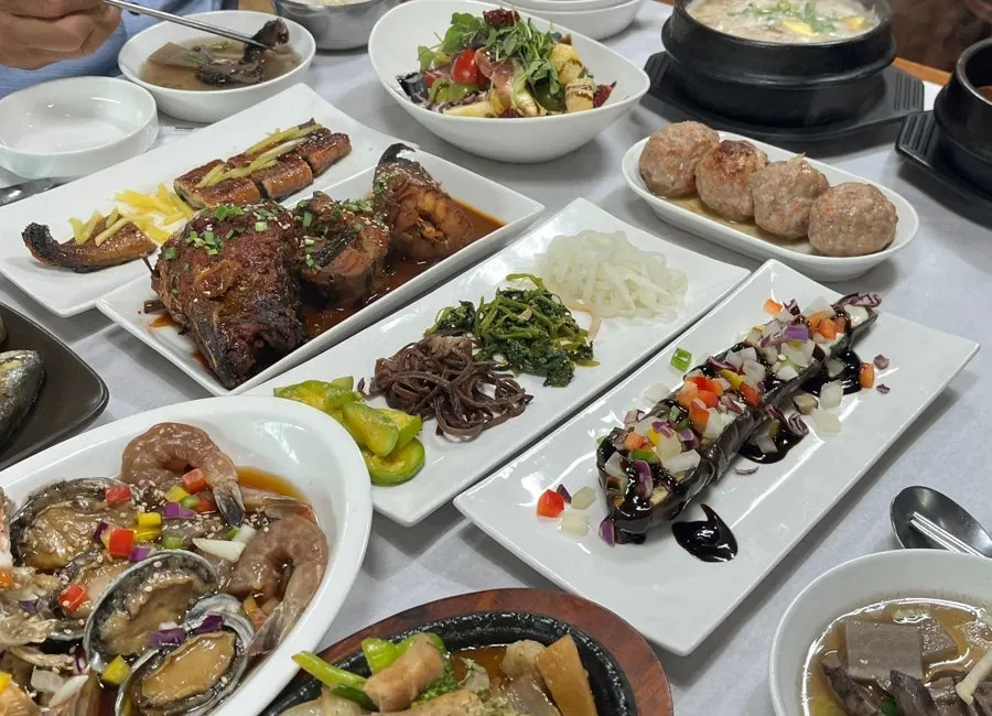 Table filled with over 20 hanjeongsik side dishes