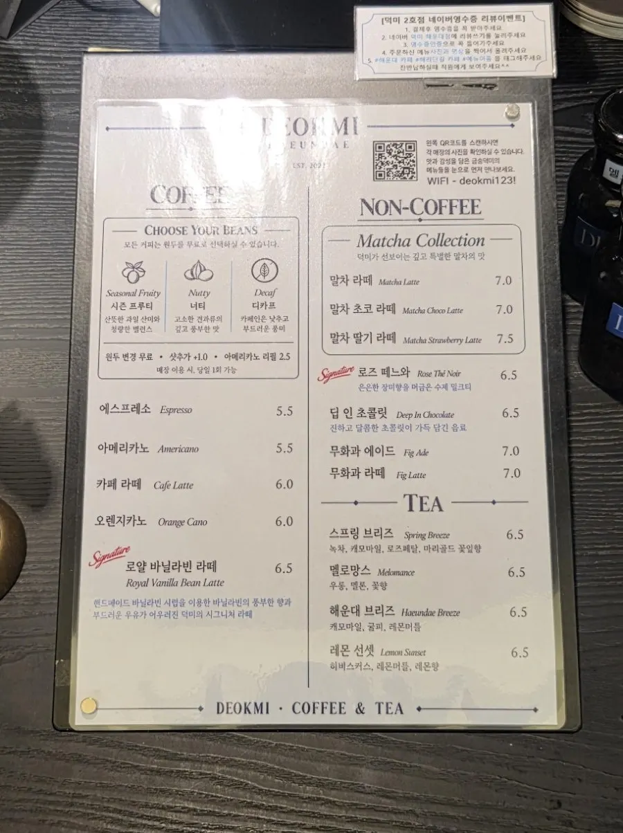 원형 테이블과 창가 좌석이 있는 넓은 카페 내부