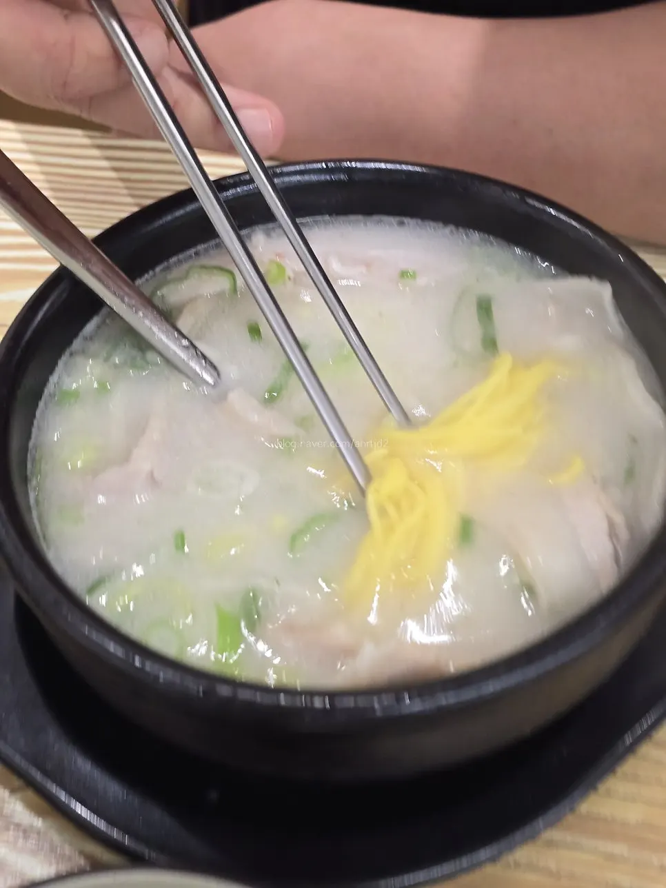 A bowl of pork jowl soup topped with chives