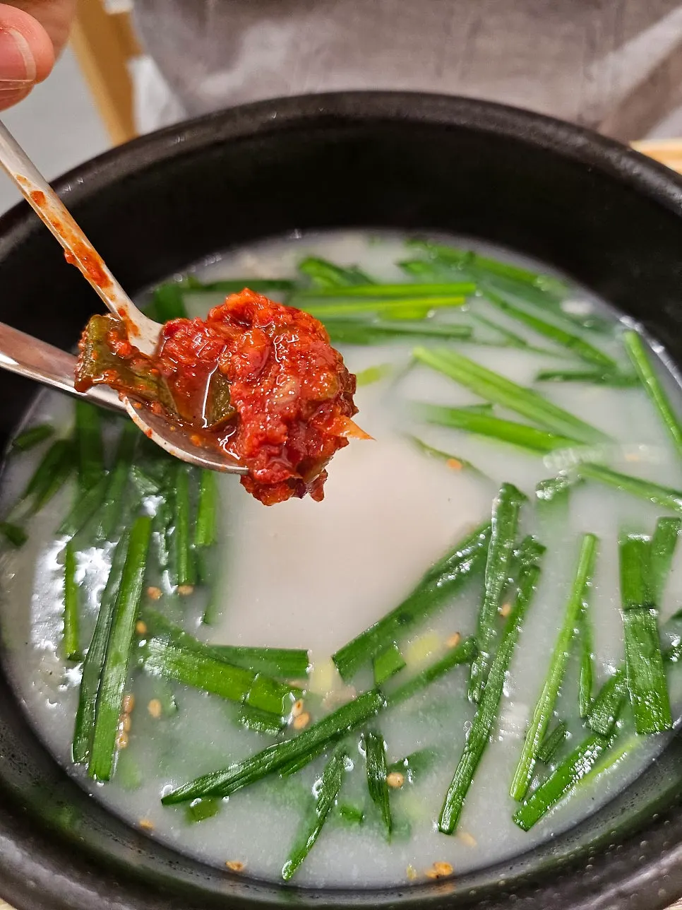 Scooping up meat from inside the pork jowl gukbap