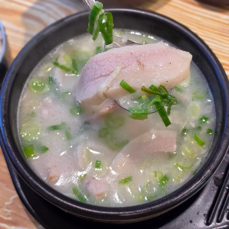 A bowl of pork jowl gukbap piled high with meat