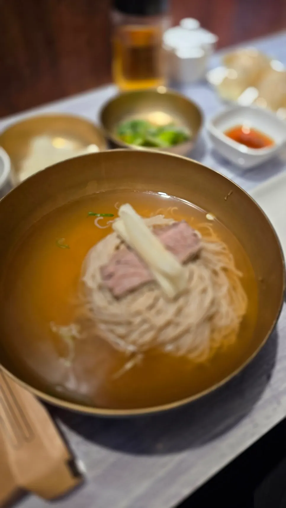 Close-up of pyeongyang naengmyeon topped with meat and pear