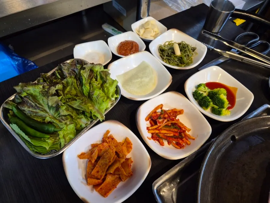 Two servings of pork belly with aged kimchi, mushrooms and onions