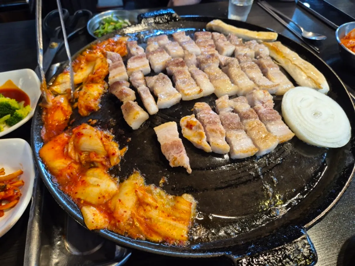 Pork belly cooking on the cauldron lid