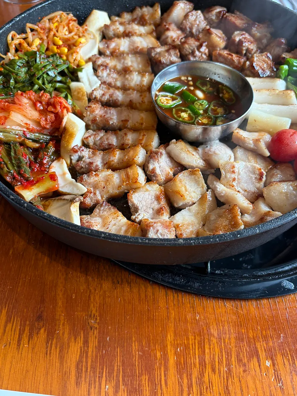 Grill topped with rice cake, tomato, mushroom, kimchi, and bean sprouts