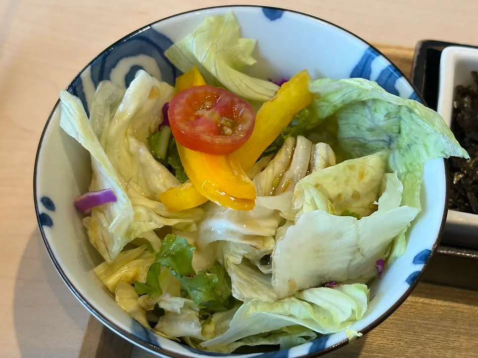 Side dishes served alongside, including salad and steamed egg
