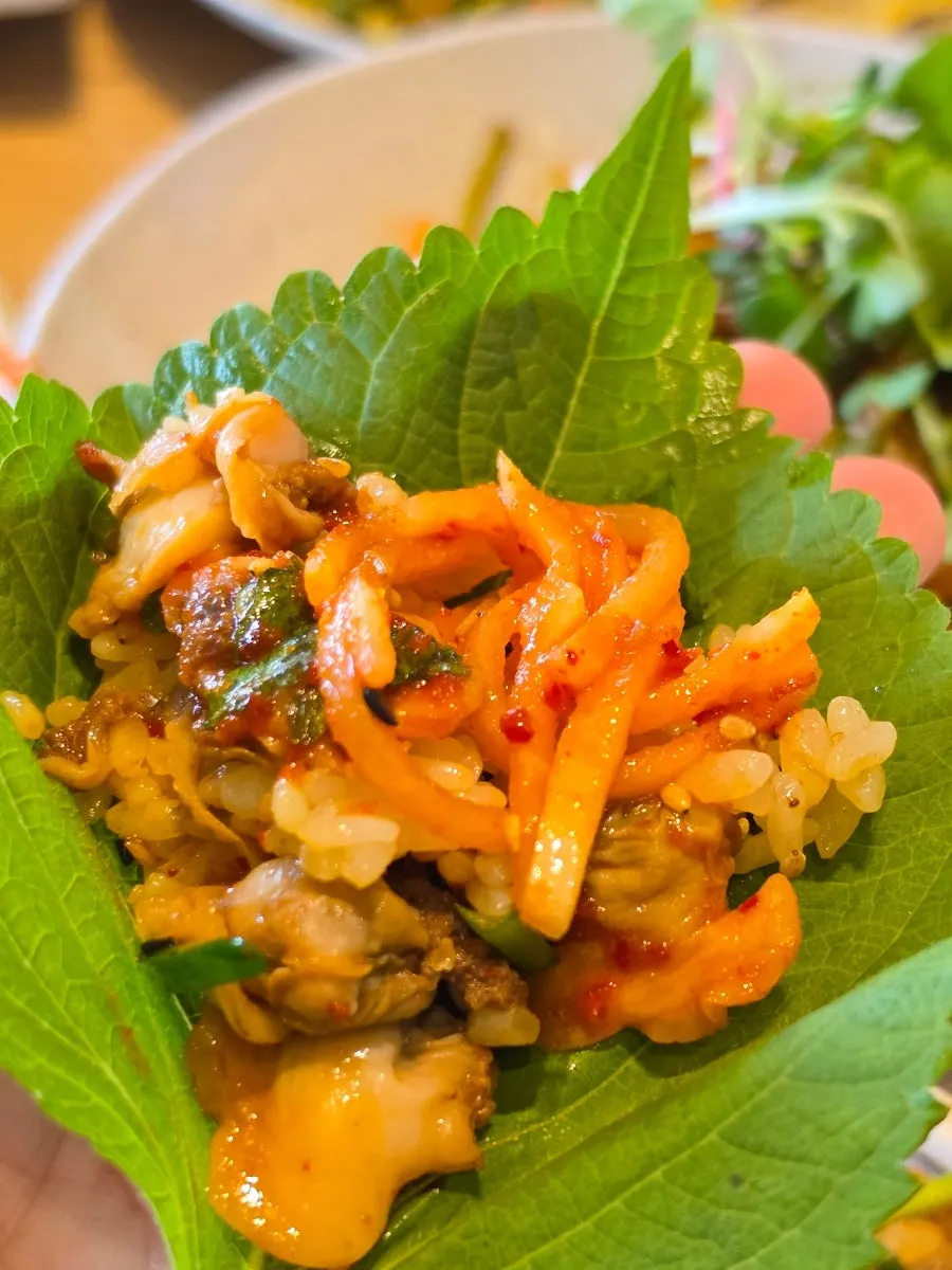 Cockle bibimbap eaten with perilla leaf