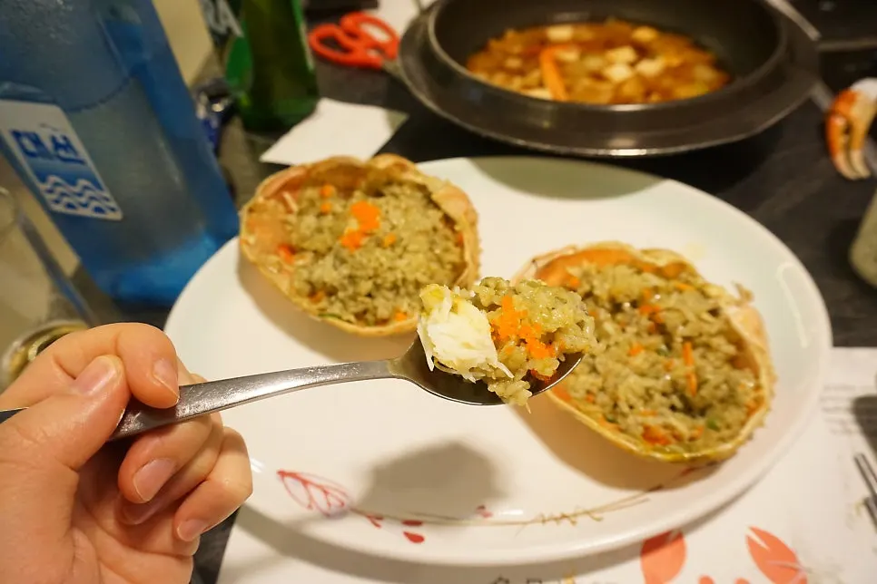 A spoonful of fried rice topped with crab meat