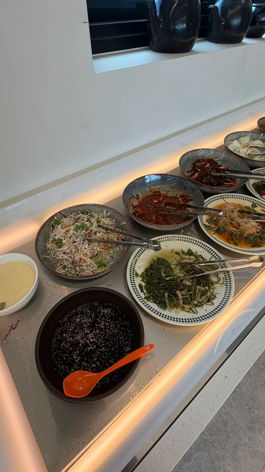 Self-bar side dishes laid out like a Korean buffet
