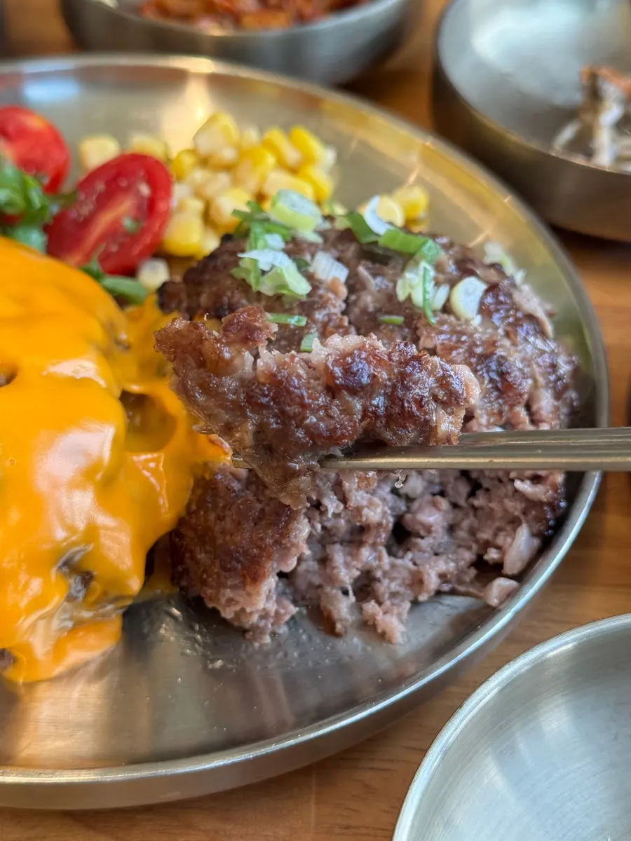 A piece of tteokgalbi picked up with chopsticks