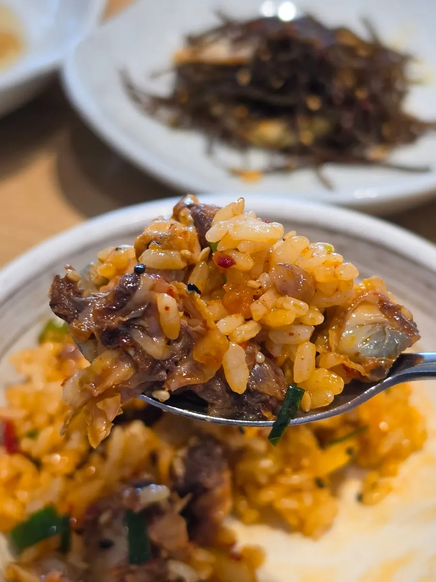 A spoonful of bibimbap loaded with cockles