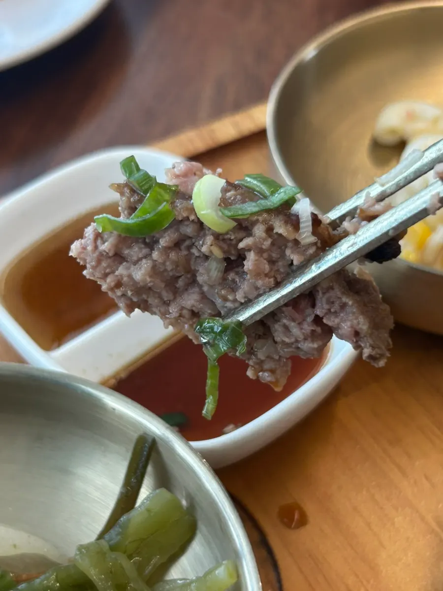A piece of tteokgalbi dipped in sauce