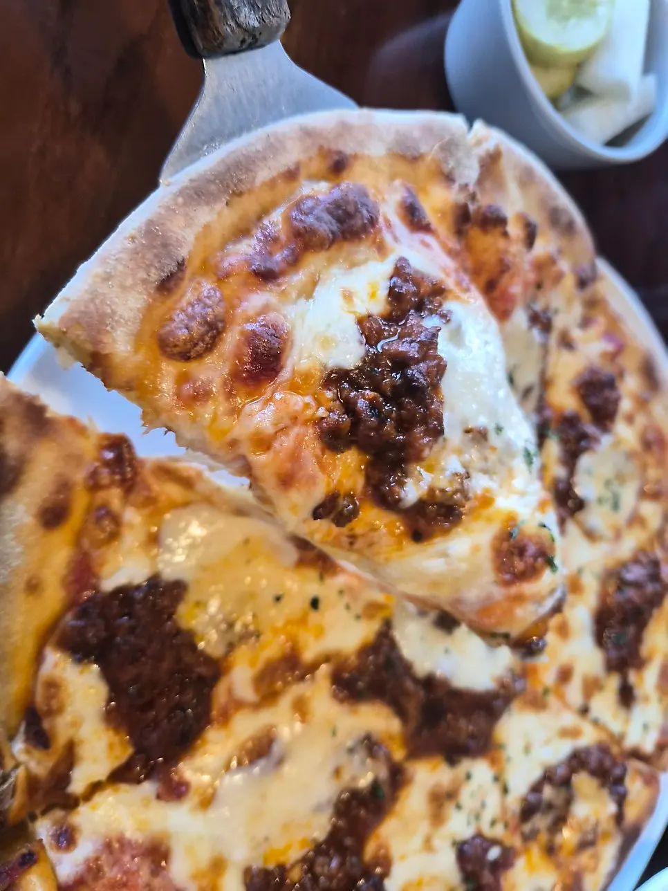 Pizza topped with ragu sauce and mozzarella cheese