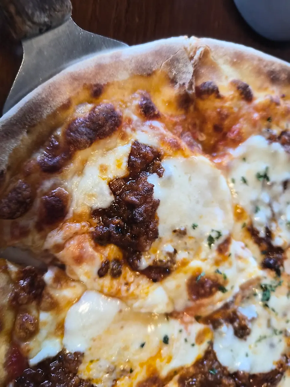 A slice of ragu pizza with hand-kneaded dough