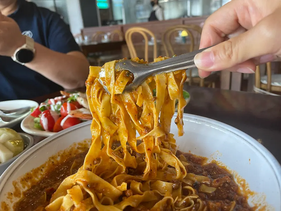 A forkful of fresh ragu pasta being lifted