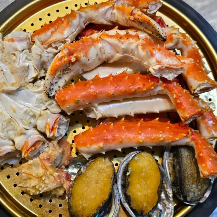 전복 서비스가 곁들여진 킹크랩 상차림