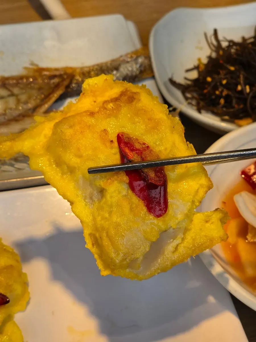 꼬막 반찬을 밥에 올려 비빈 모습