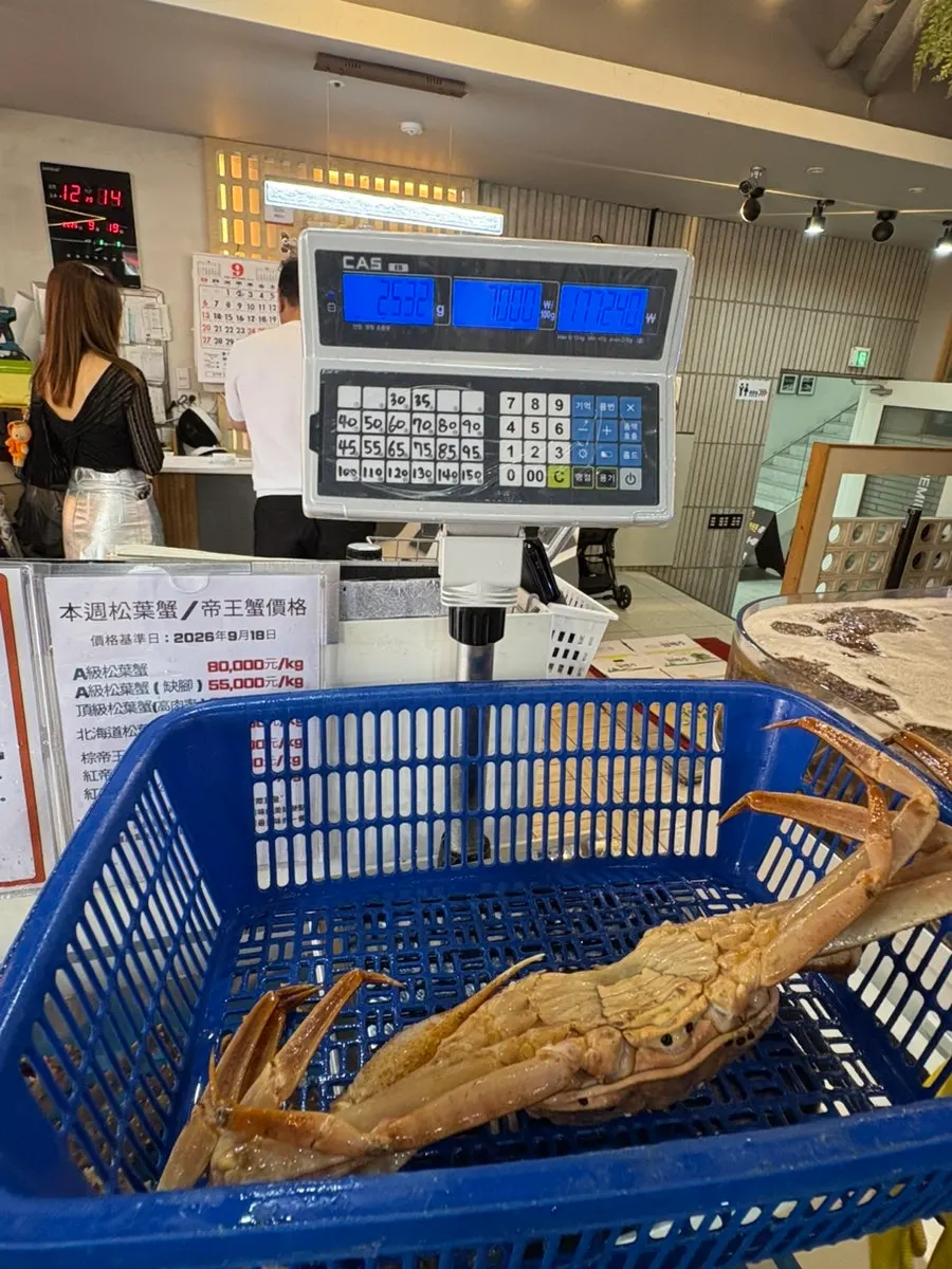 The crab being weighed on the scale without the basket