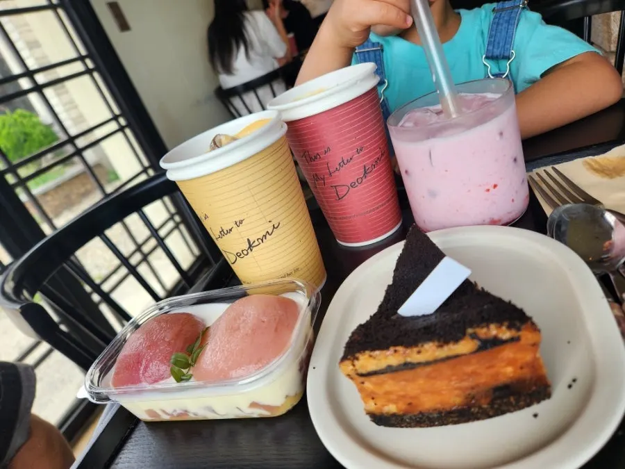 Two plates of cake with coffee at Deokmi Gijang Branch