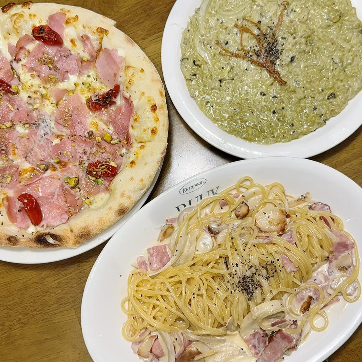 Table with carbonara and jambon pizza