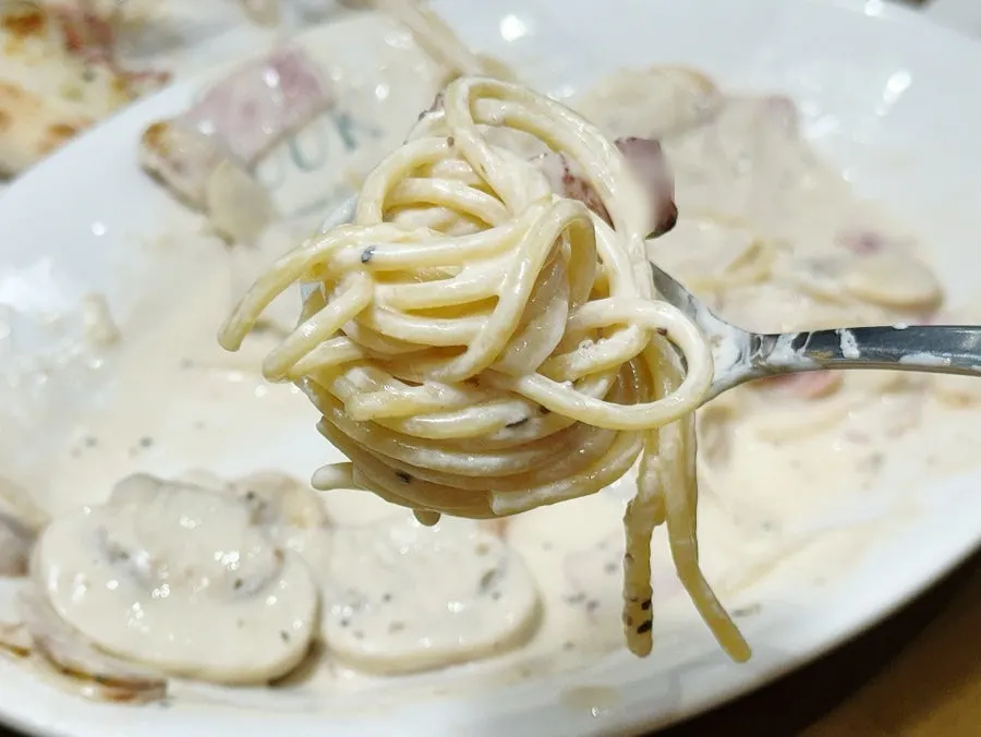 Cream pasta noodles lifted with a fork