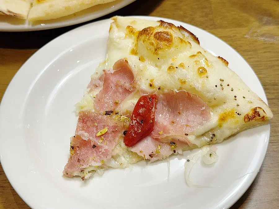 One slice removed from the jambon pizza