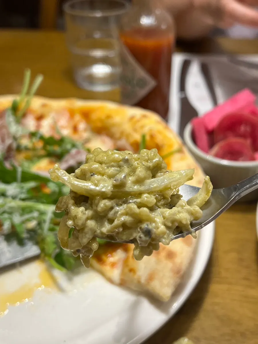 A spoonful of abalone cream risotto lifted from the plate