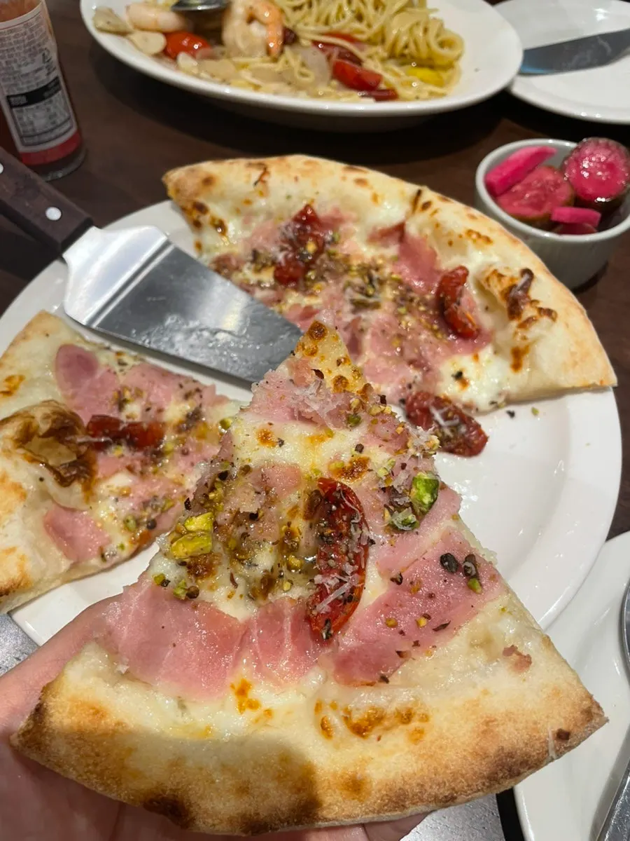 Close-up of pizza topped with jambon and crushed pistachio