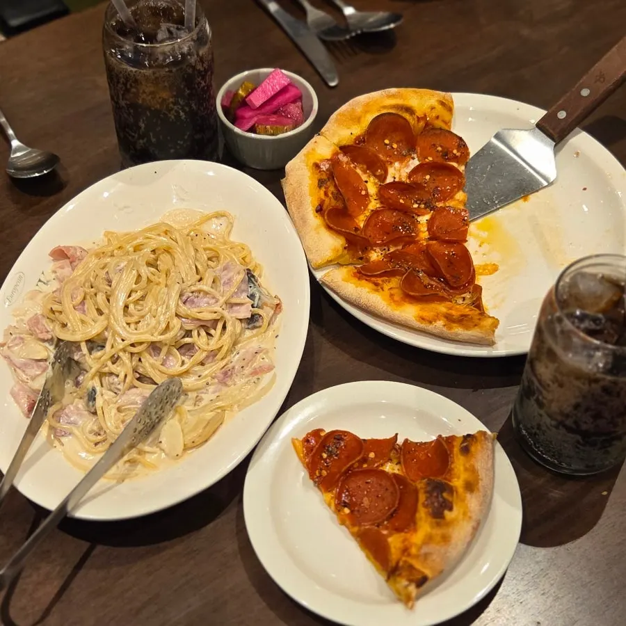 Pepperoni pizza and carbonara set on the table together