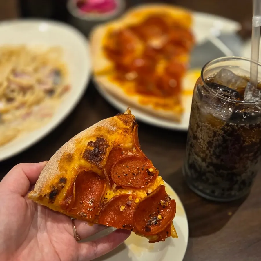 A pizza slice folded in half and held by hand