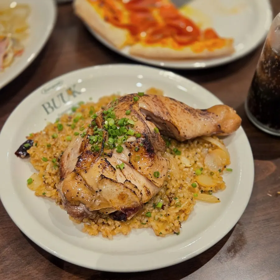 Kung pao chicken pilaf topped with a whole chicken leg