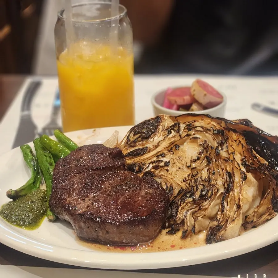 Large grilled cabbage served alongside the steak