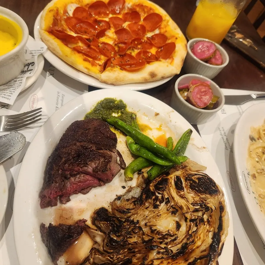 Table with steak and pizza together